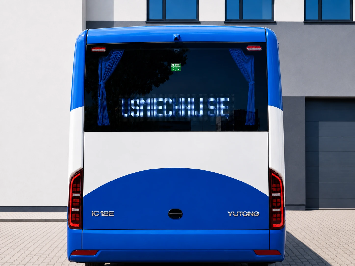 Tył niebieskiego autobusu Yutong z tablicą LED wyświetlającą komunikat UŚMIECHNIJ SIĘ